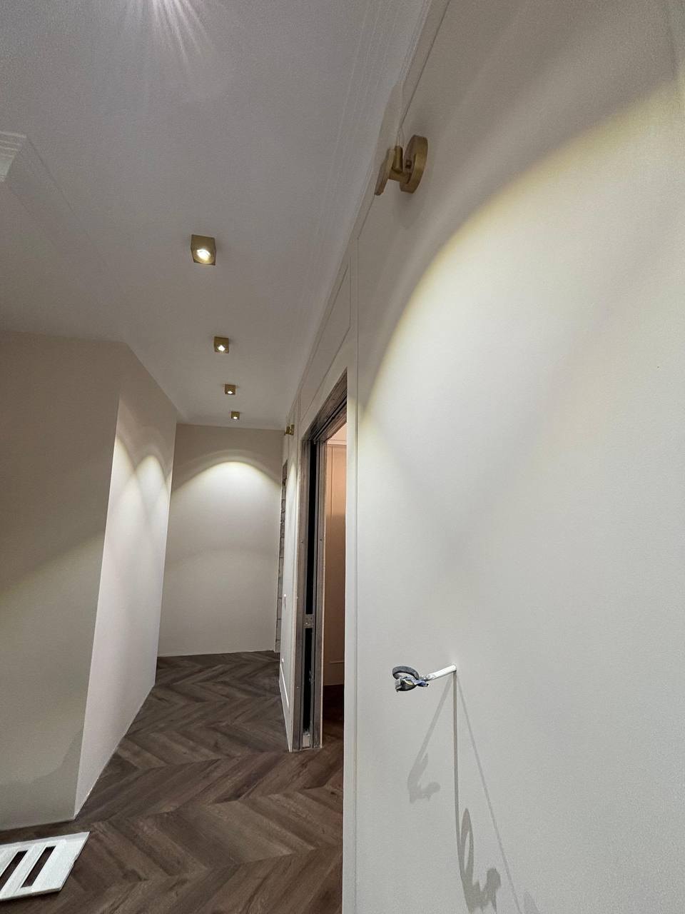 ЖК Сердце Столицы, 75 м², ремонт в работе: коридор, паркет ёлочкой уже уложен, белые стены, точечные светильники